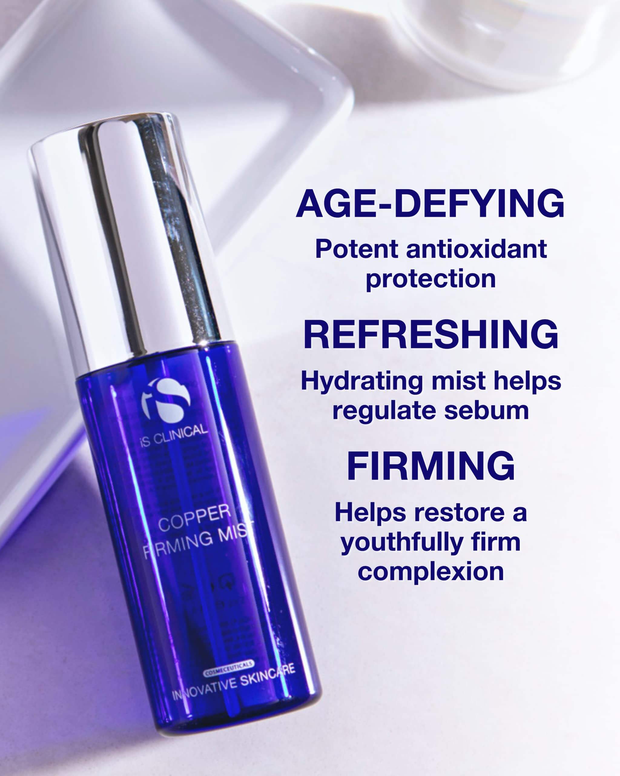iS Clinical Copper Firming Mist in a blue bottle with text highlighting age-defying, refreshing and firming benefits.