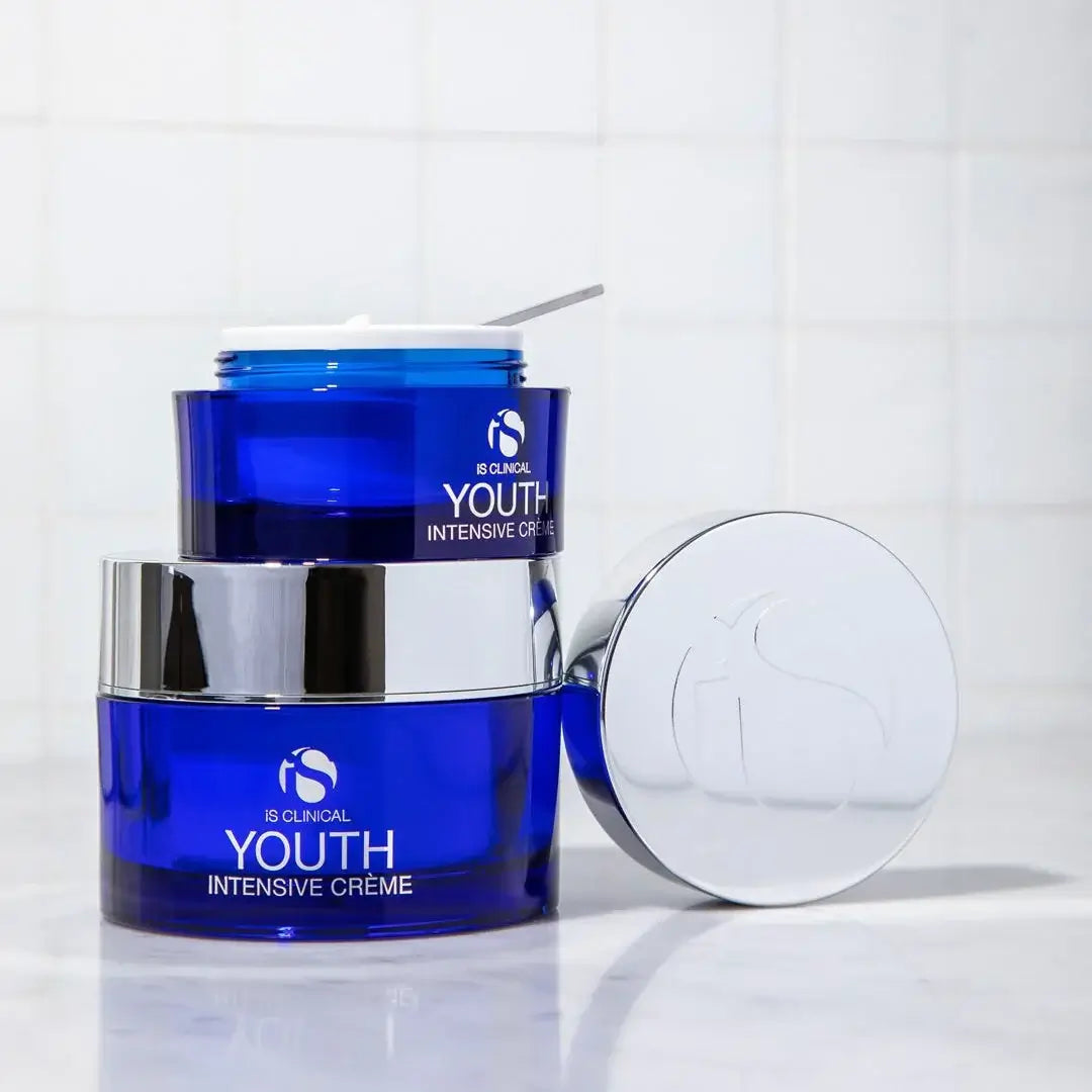 iS Clinical Youth Intensive Crème – Anti-Ageing Peptide Moisturiser 50g / 100g in blue jars on a countertop.