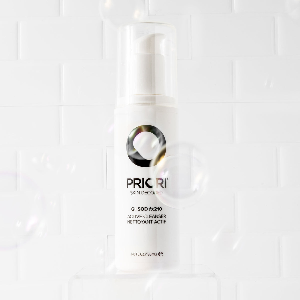 PRIORI Q+SOD Active Cleanser bottle on a white tiled background