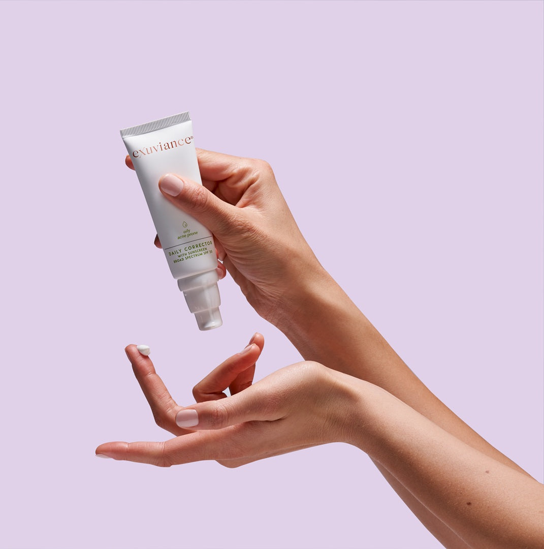 Exuviance Daily Corrector SPF 35 held in hand