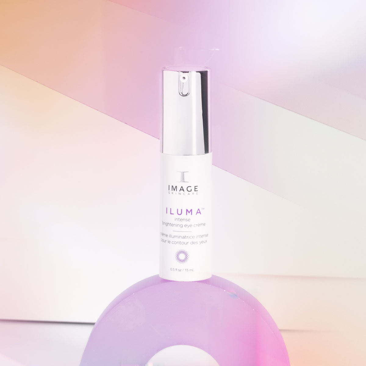 IMAGE Skincare ILUMA Intense Brightening Eye Crème pump on a pastel background