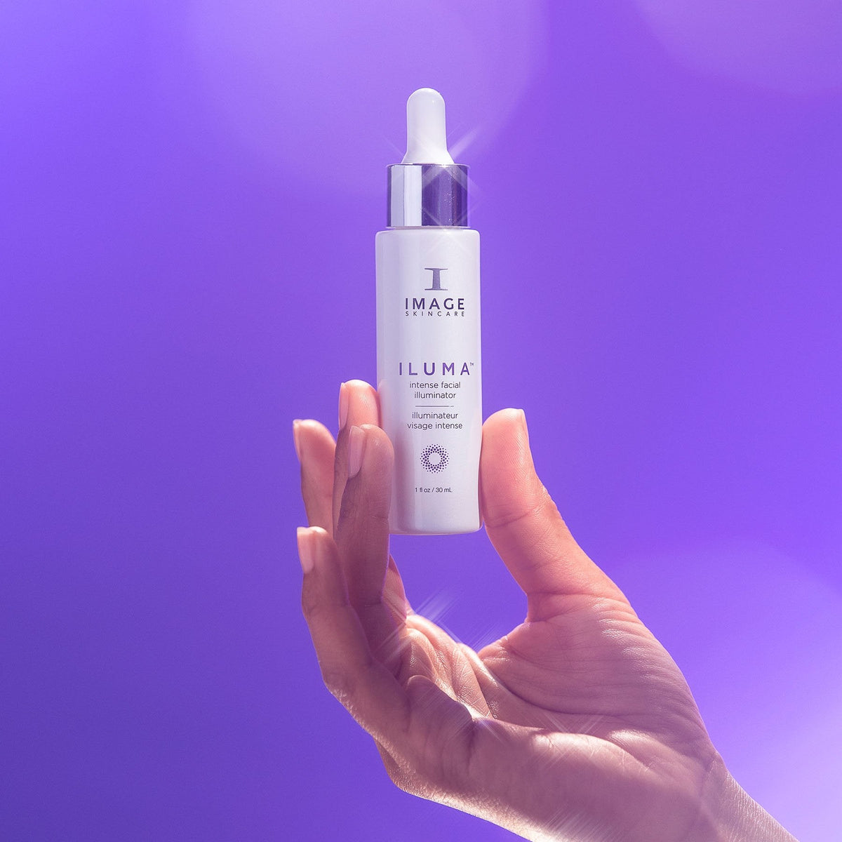 IMAGE Skincare ILUMA Intense Facial Illuminator bottle held against a purple background