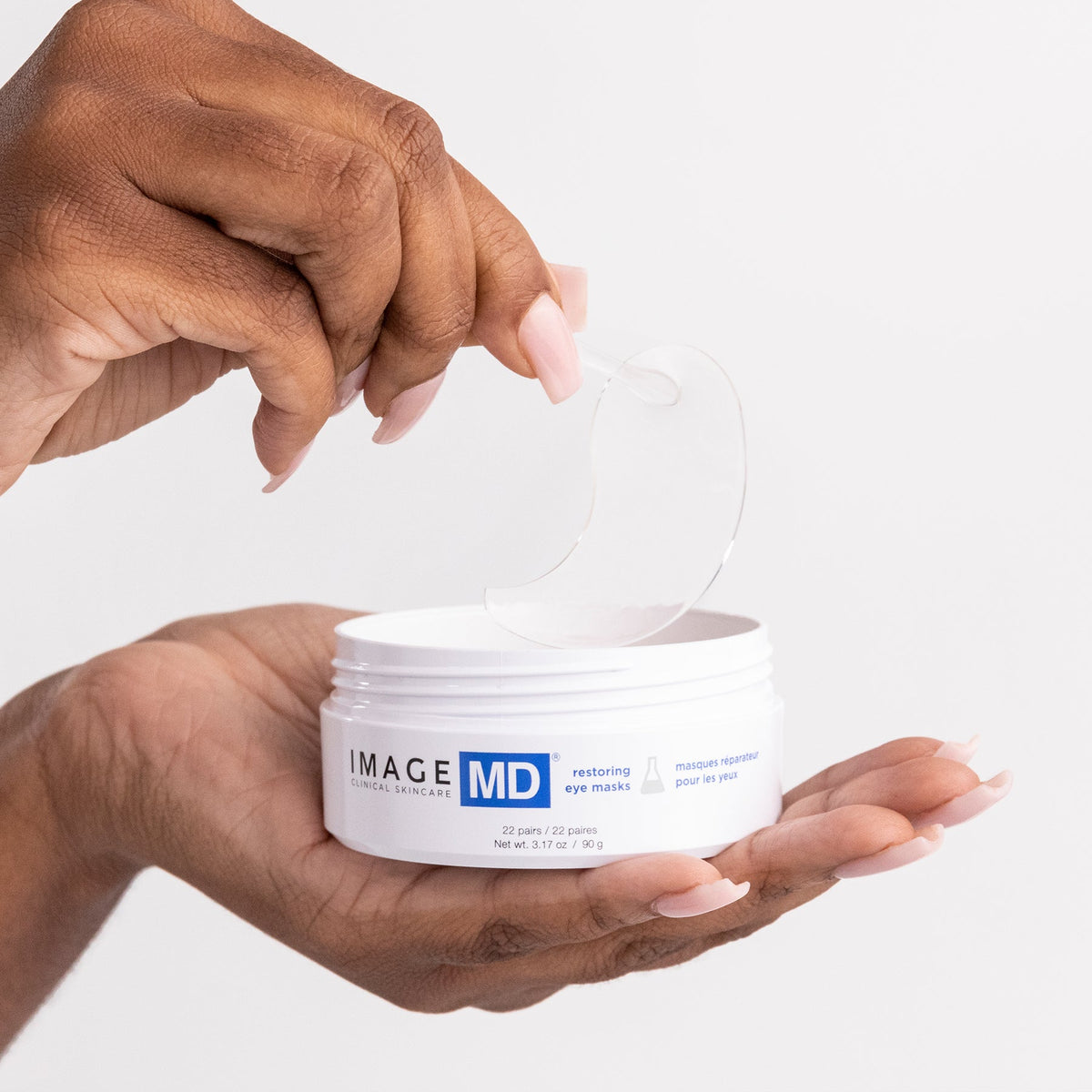 IMAGE Skincare MD Restoring Eye Masks lifting a hydro-gel mask from the jar