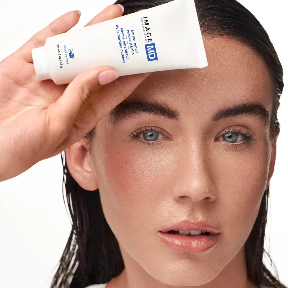 IMAGE Skincare MD Barrier Repair Recovery Balm held by a model with fresh, calm-looking skin