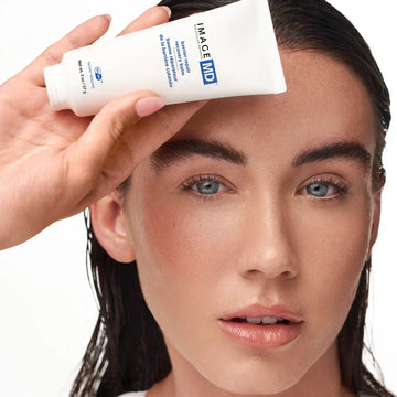 IMAGE Skincare MD Barrier Repair Recovery Balm held by a model with fresh, calm-looking skin