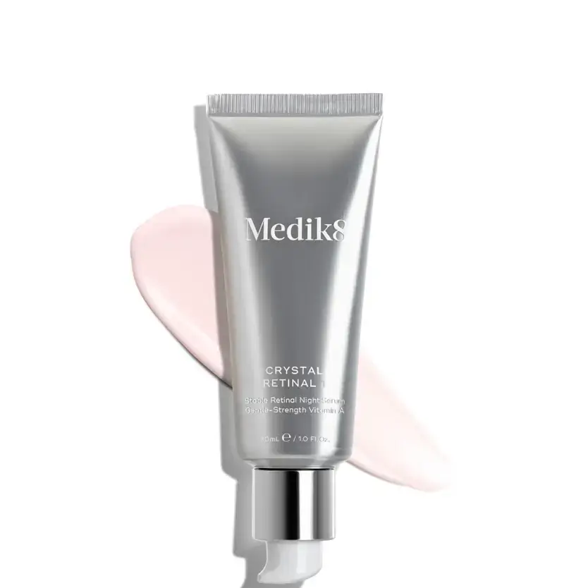 Medik8 Crystal Retinal 1™ tube with pink cream swatch, gentle retinaldehyde for sensitive skin.