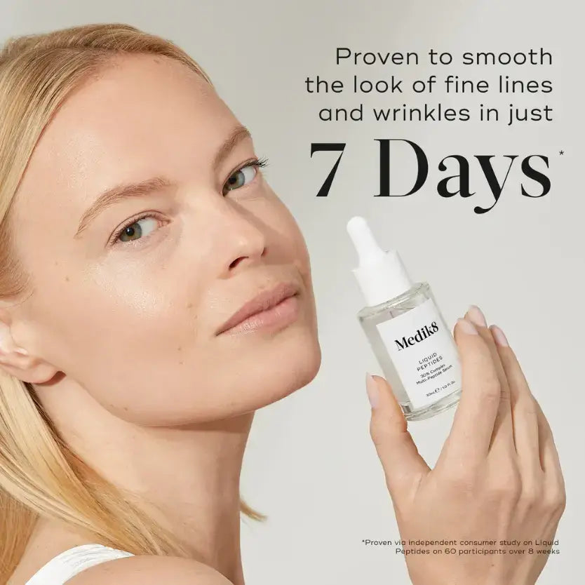 Model holding Medik8 Liquid Peptides™ serum, showcasing its effectiveness in smoothing fine lines in 7 days.