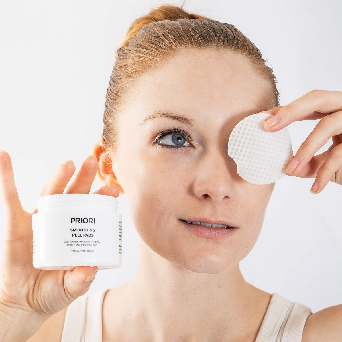 PRIORI Smoothing Peel Pads pad being used on the face