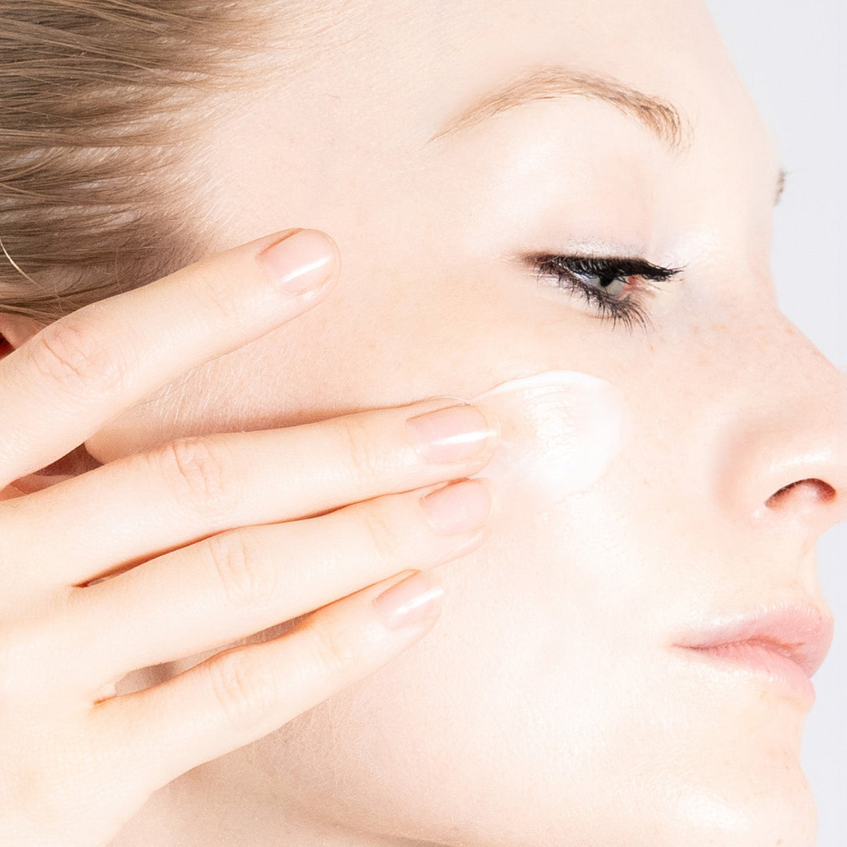 PRIORI Q+SOD Age Renew Moisturizing Cream being applied to the cheek
