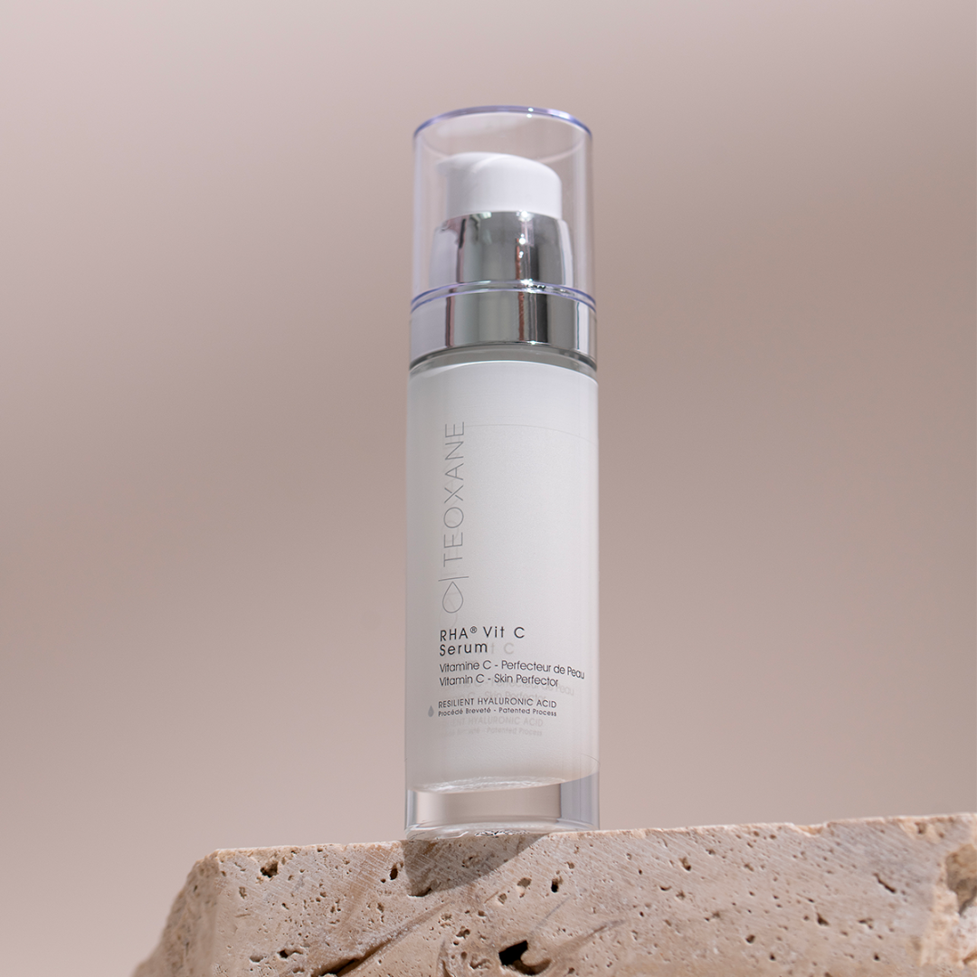 Teoxane RHA Vit C Serum bottle on stone for a radiant even-looking complexion