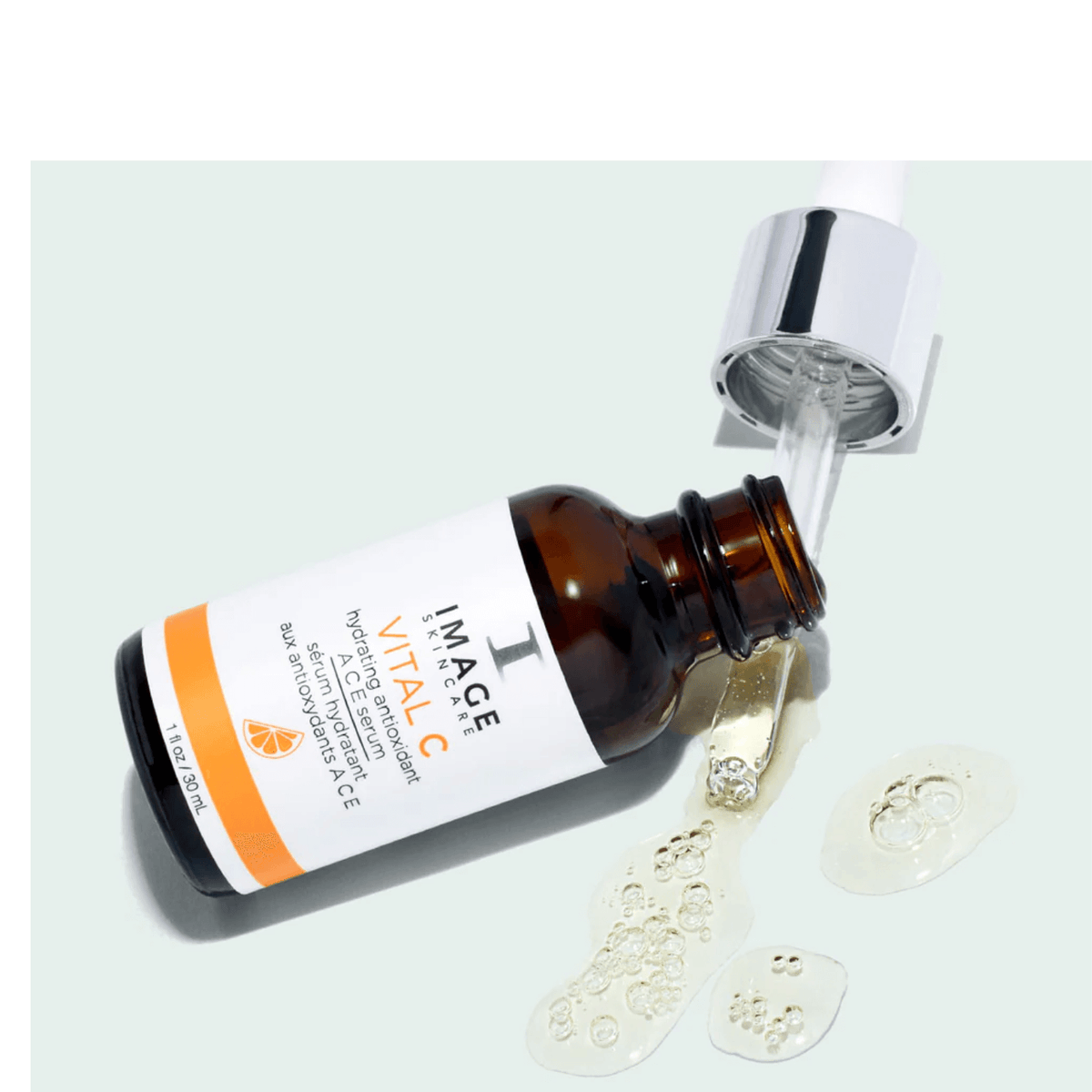 IMAGE Skincare VITAL C Hydrating Antioxidant A C E Serum bottle with dropper and serum droplets on a pale blue background