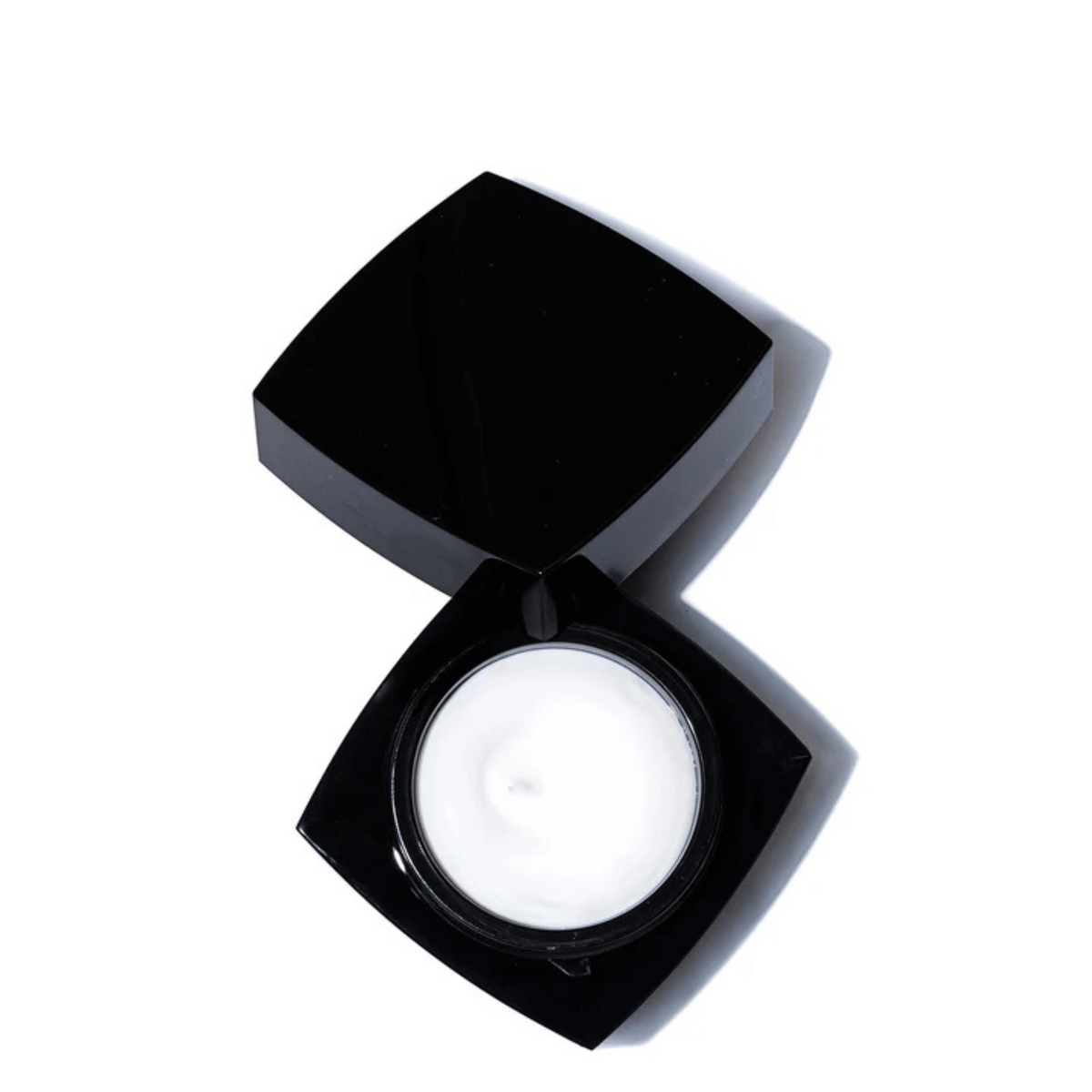 Revision Skincare Firming Night Treatment in an open black jar showcasing the rich night cream inside.